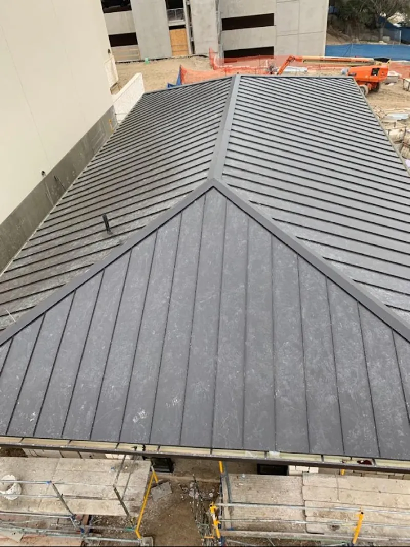 Commercial metal roof construction with crane equipment in Carlsbad